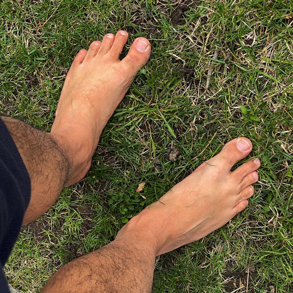 Masculine male bare feet on grass